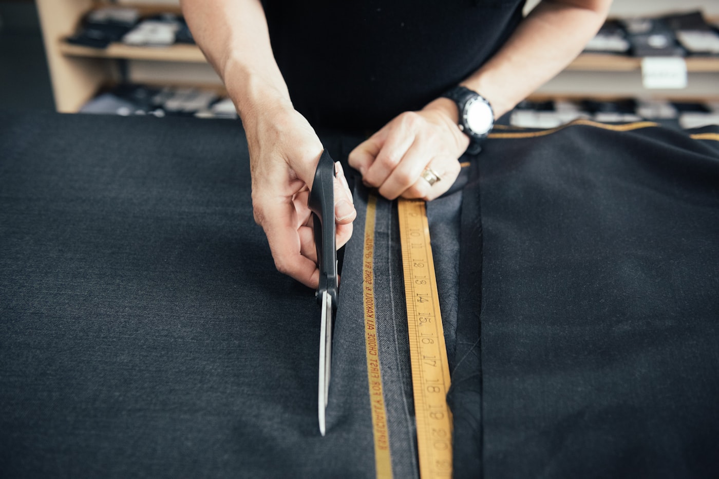 Cloth being cut on a tailor's bench
